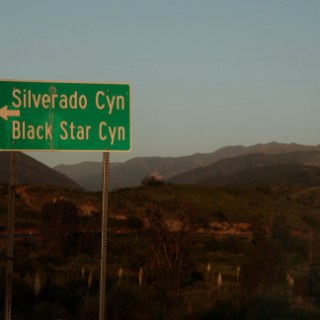a sign with a mountain in the background