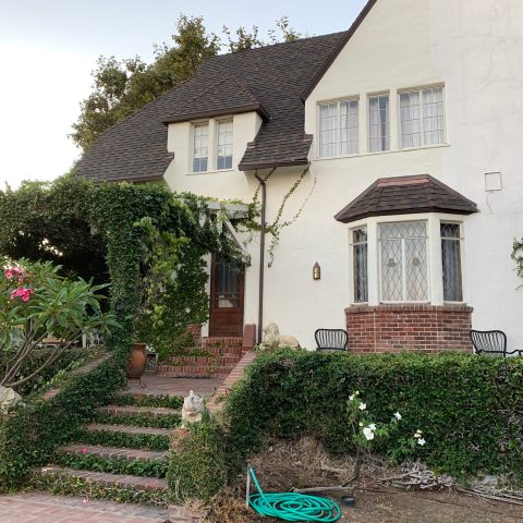 a house with bushes in front of a building