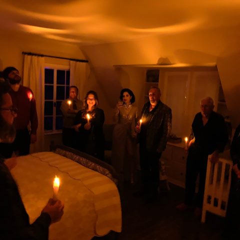 a group of people standing in front of a cake with lit candles