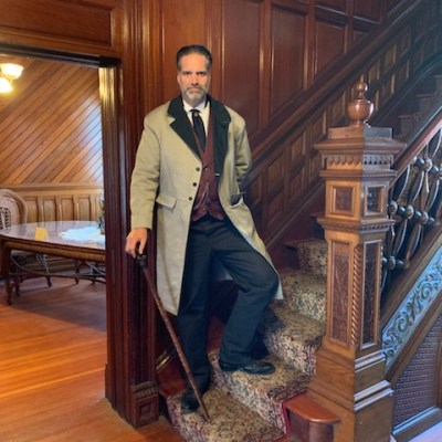a person wearing a suit and tie standing in a room
