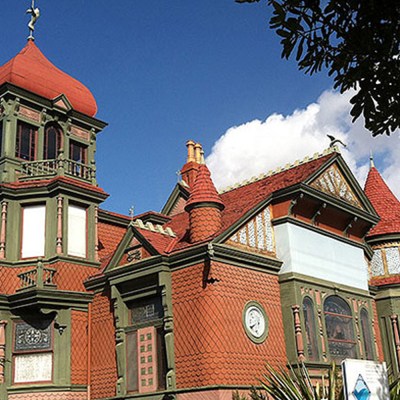 a small clock tower in front of a brick building