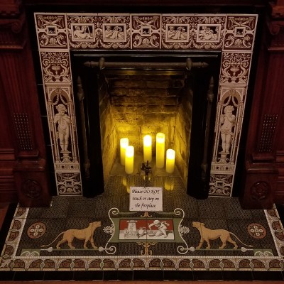 a glass of wine next to a fireplace