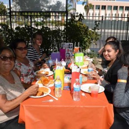a group of people sitting at a table eating food
