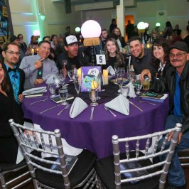 a group of people sitting at a table in front of a crowd