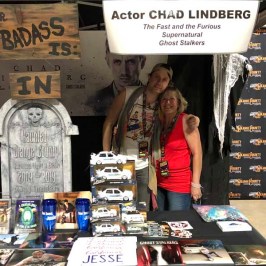 Chad Lindberg sitting at a table with a sign