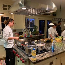 a group of people standing in a kitchen preparing food