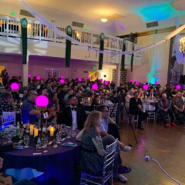 a group of people sitting at a table in front of a crowd