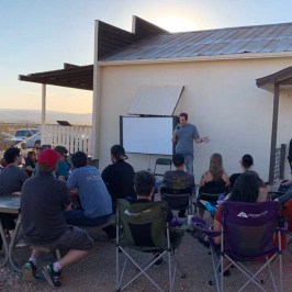 a group of people sitting in front of a building