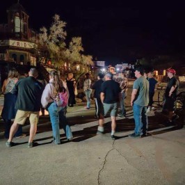 a group of people standing on a sidewalk