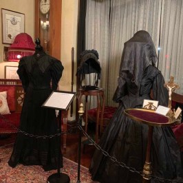 a person sitting on a chair in front of a curtain