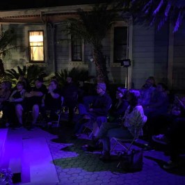 a group of people performing on stage in front of a building