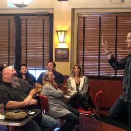 a group of people sitting at a table in front of a window