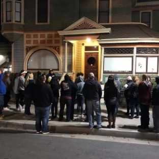 a group of people crossing a street in front of a building
