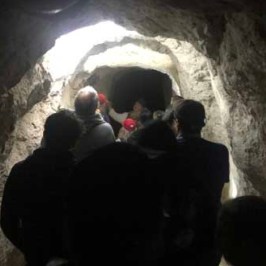 a group of people standing in front of a cave
