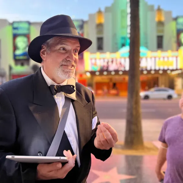 a man wearing a suit and tie walking down the street