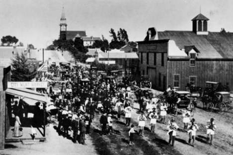 a vintage photo of a group of people walking down a street