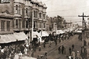 a vintage photo of a group of people walking down a street
