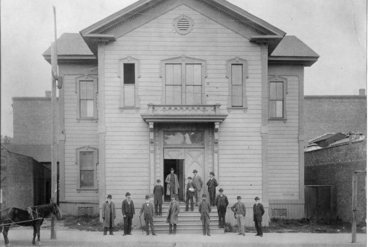 a group of people walking in front of a house